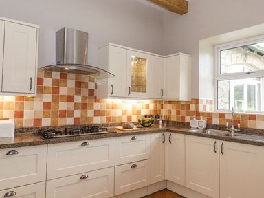 A kitchen with cabinets and a sink at The Gatehouse in 