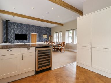 A kitchen with cabinets and a dining area at The Gatehouse 