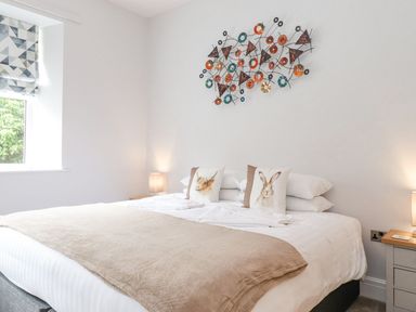 A bedroom with a bed and wall art at The Gatehouse in 