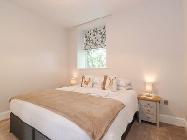 A bedroom with a bed and bedside table at The Gatehouse