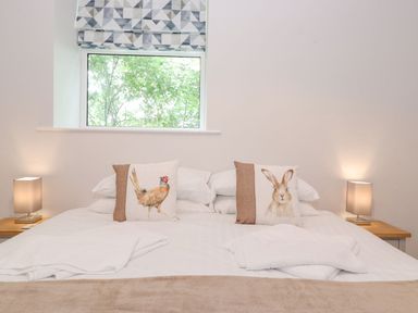A bedroom with a bed and decorative pillows at The Gatehouse 