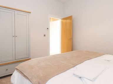 A bedroom with a bed and wardrobe at The Gatehouse