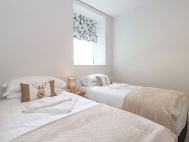 A bedroom with two beds and a window at The Gatehouse 