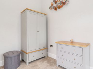 A bedroom with a wardrobe and a chest of drawers at The Gatehouse 