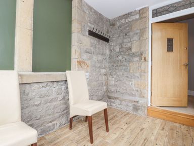 A hallway with stone walls and a door at The Gatehouse