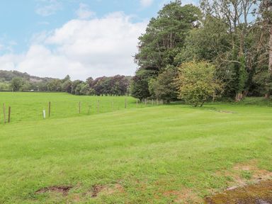 A field with trees and a fence at The Gatehouse