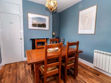 A dining room with a wooden table and chairs at Dinguardi Seahouses
