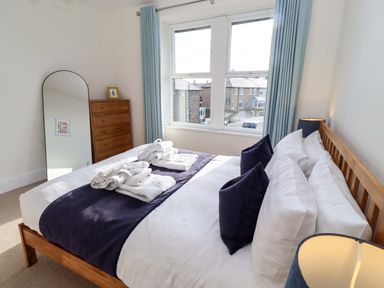 A bedroom with a bed and dresser at Dinguardi in Seahouses