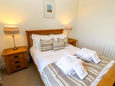 A bedroom with a bed and bedside table at Dinguardi in Seahouses