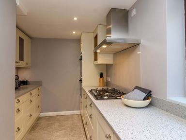 A kitchen with cabinets and a gas stove at 1 Eastdon Cottages in Exeter