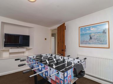 A game room with a foosball table and a television at 1 Eastdon Cottages in Exeter