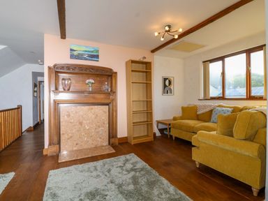 A living room with a fireplace and sofa at 1 Eastdon Cottages in Exeter