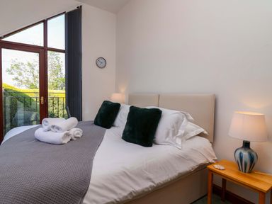 A bedroom with a bed and bedside lamp at 1 Eastdon Cottages in Exeter