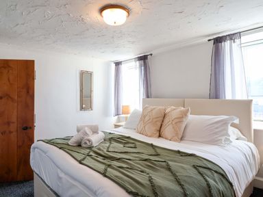 A bedroom with a bed and window at 1 Eastdon Cottages in Exeter