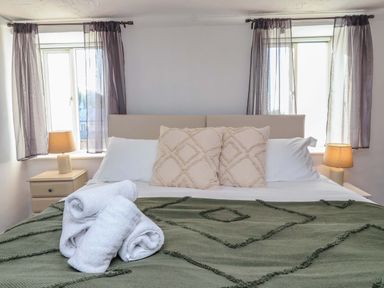 A bedroom with a bed and towels at 1 Eastdon Cottages in Exeter