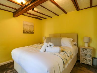 A bedroom with a bed and bedside table at 1 Eastdon Cottages Exeter