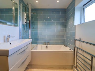 A bathroom with a bathtub and wash basin at 1 Eastdon Cottages Exeter