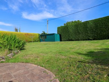 A garden with a shed and grass at 1 Eastdon Cottages in Exeter