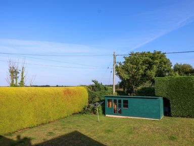 A garden with a shed and hedge at 1 Eastdon Cottages Exeter