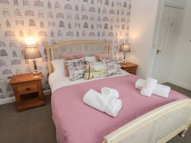 A bedroom with a double bed and bedside tables with lamps at The Smithy in Chathill near Seahouses