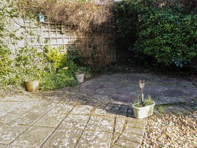 A garden area with stone and gravel ground covering and potted plants at Samson's Place Morfa Bychan