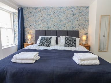A bedroom with a bed and bedside tables at 21A High Street in Jedburgh