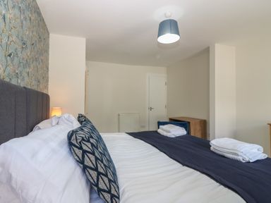 A bedroom with a bed and dresser at 21A High Street in Jedburgh