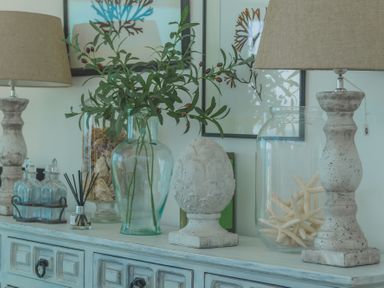 A sideboard with lamps glass jars and decorative items at Oystercatcher Mevagissey