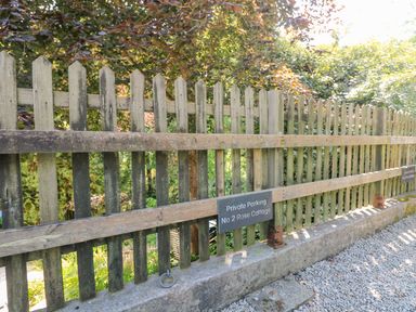 A wooden fence with a sign for private parking at No 2 Rose Cottage in St Agnes