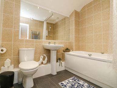 A bathroom with a toilet sink bathtub mirror and towel rail at Buddicombe House in Combe Martin