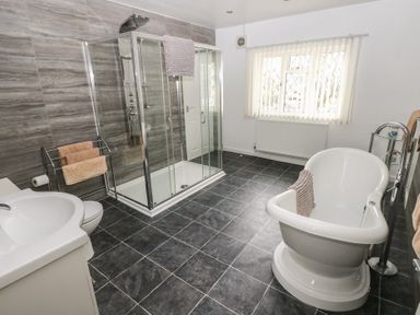 A bathroom with a freestanding bathtub a glass shower enclosure a sink and a towel rack at Greenhaven in Narberth
