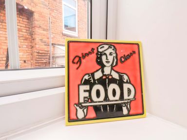 A decorative sign with a woman holding a tray labeled FOOD at 59 Moorland Road Scarborough