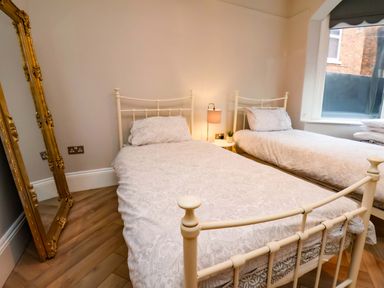 A bedroom with two beds and a mirror at 59 Moorland Road Scarborough