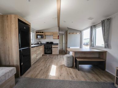 A kitchen with appliances and dining area at Billy’s Way - Hayling Island