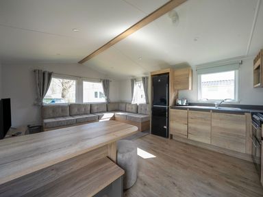 A living room with seating and kitchen appliances at Sand and Splash - Hayling Island