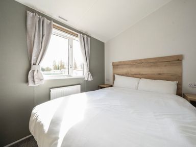 A bedroom with a bed and window at Sand and Splash - Hayling Island
