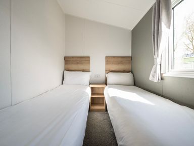 A bedroom with two single beds and a window at Sand and Splash - Hayling Island
