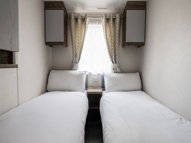 A bedroom with two single beds and a window at Wavecrest - Hayling Island