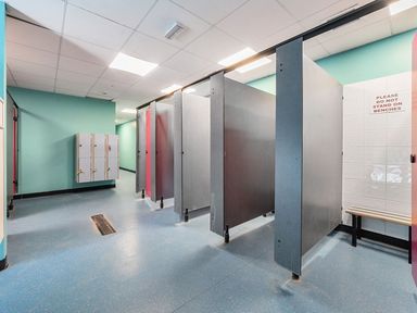 A changing room with lockers and shower cubicles at Wavecrest - Hayling Island