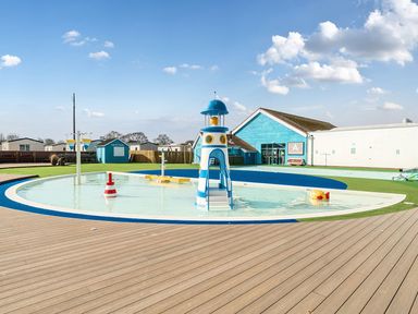 An outdoor water play area with a play structure and pool at Wavecrest - Hayling Island Holiday Park