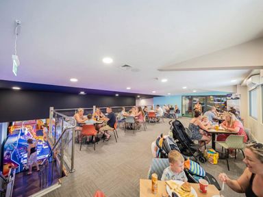 A dining area with people eating and playing games at Tranquil Waters - Billing Aquadrome