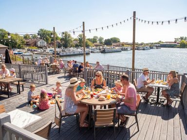 An outdoor dining area by the water at Tranquil Waters - Billing Aquadrome