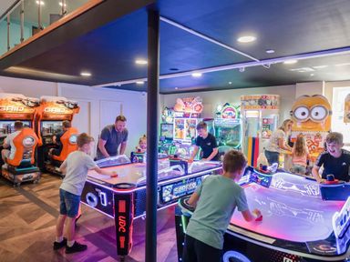 A gaming room with arcade machines and air hockey tables at Serenity Shores - Billing Aquadrome