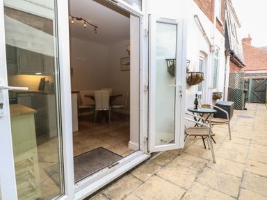 A patio with a small table and two chairs outside a kitchen and dining area at 34 North Denes Road in Great Yarmouth