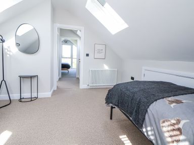 A bedroom with a bed and a skylight window at Ty Blodau near Prestatyn