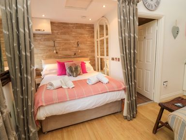 A bedroom with a bed towels and curtains at The Forge Nr Seapouses
