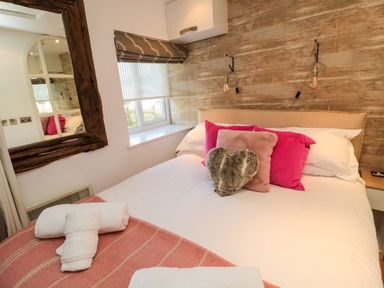 A bedroom with a bed with pillows and folded towels on a blanket at The Forge in Nr Seahouses