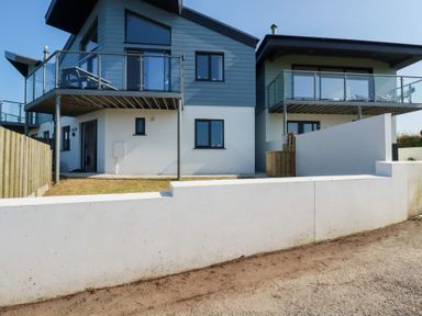 A building with balconies and a garden at Jacana in Perranporth