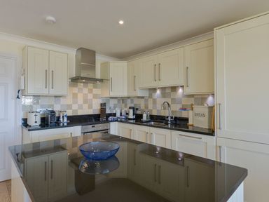 A kitchen featuring cabinets, sink, stove, toaster, and kettle at Apartment 12, Burgh Island Causeway, Bigbury-On-Sea