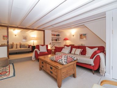 A living room with red sofas a wooden coffee table bookshelves and lamps at Springfield in Kingsand